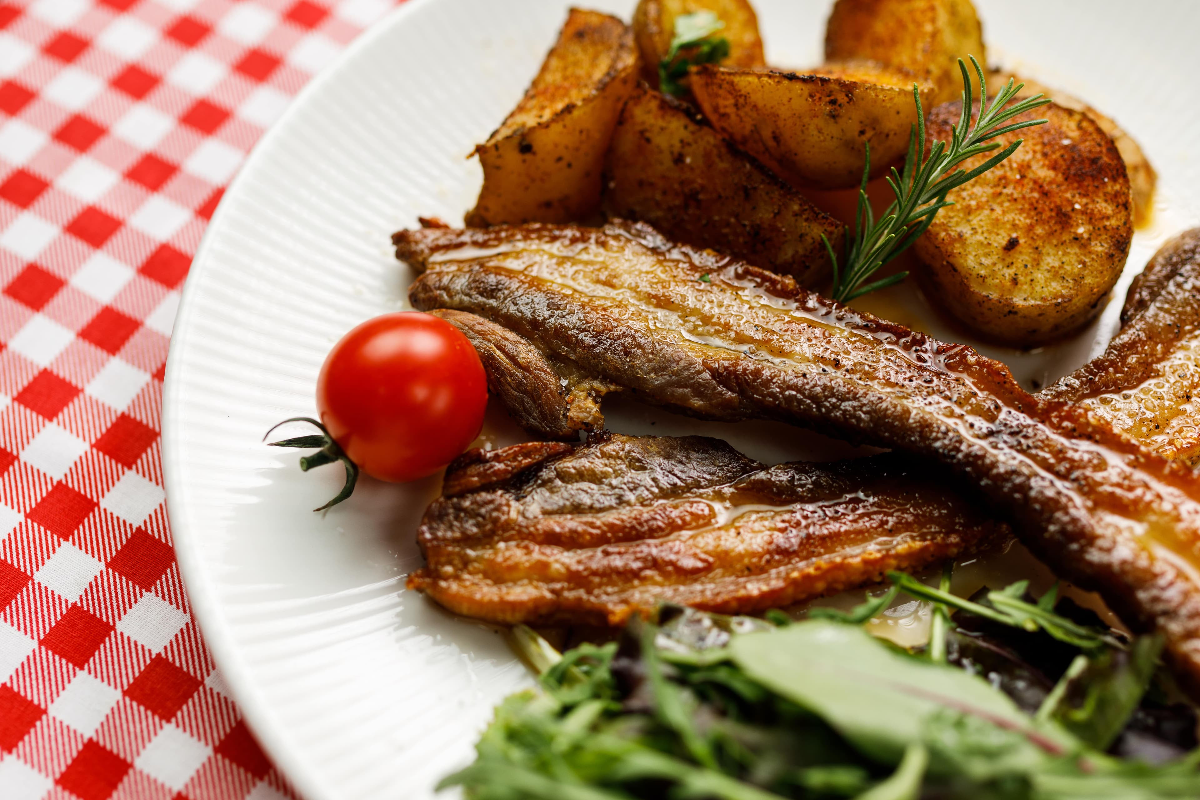 Crispy Rib Ensemble with Roasted Potatoes and Vibrant Greens